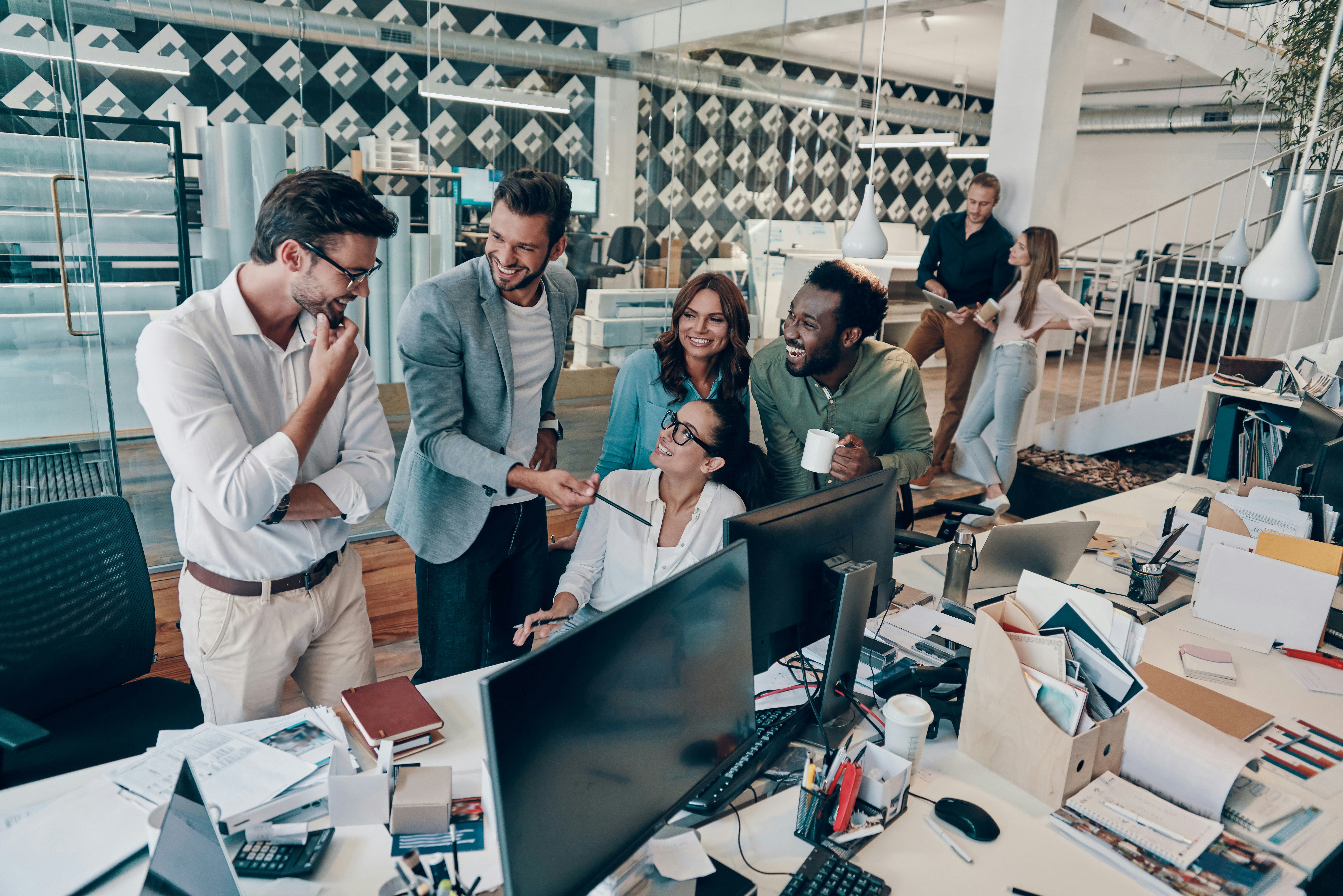 •	A workplace scene where one team is highly engaged while another nearby team appears disengaged or unsupported.
