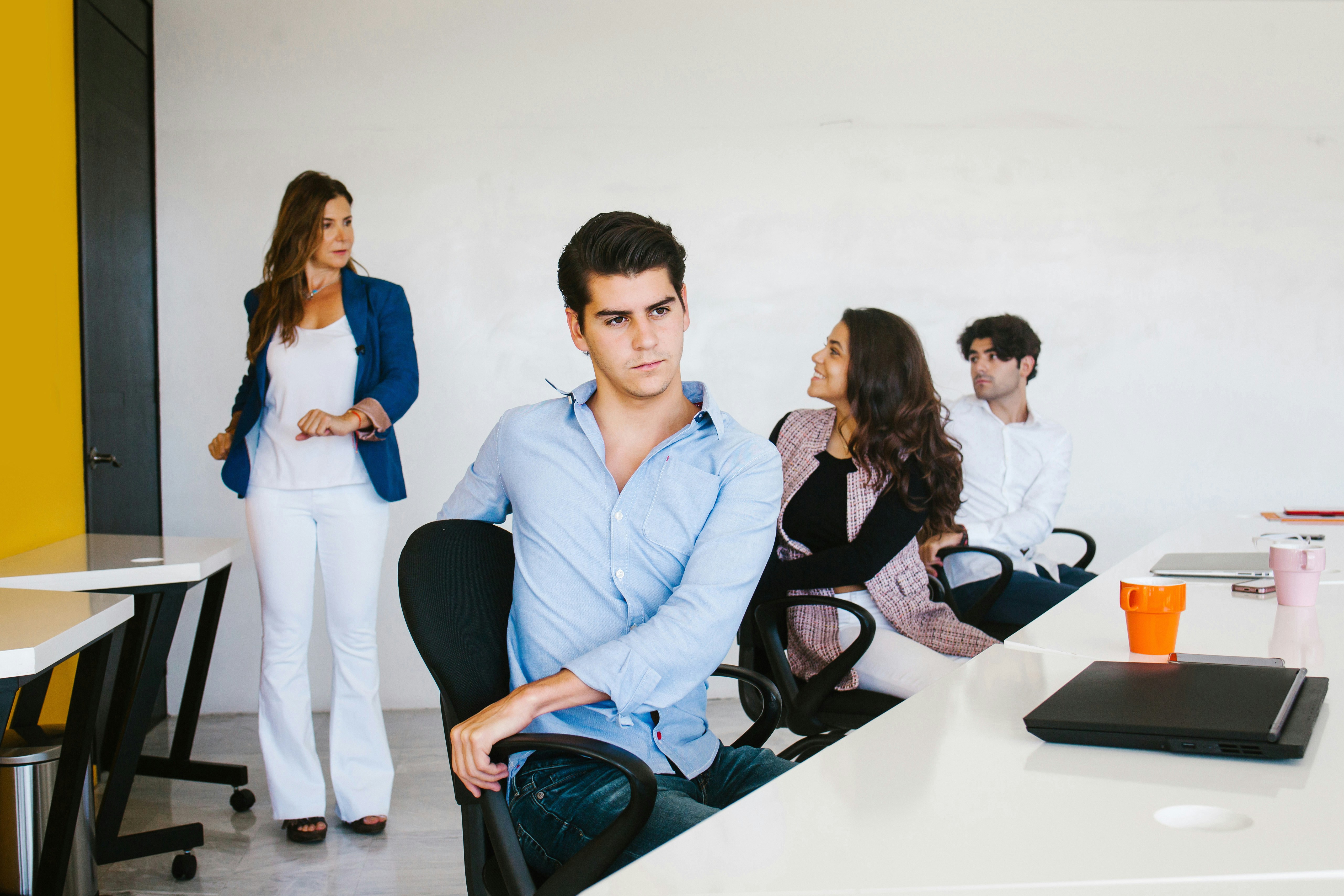 A lone professional or small group in a modern workplace, paused rather than “in motion” Expressions that suggest thought, uncertainty or quiet tension, not forced positivity