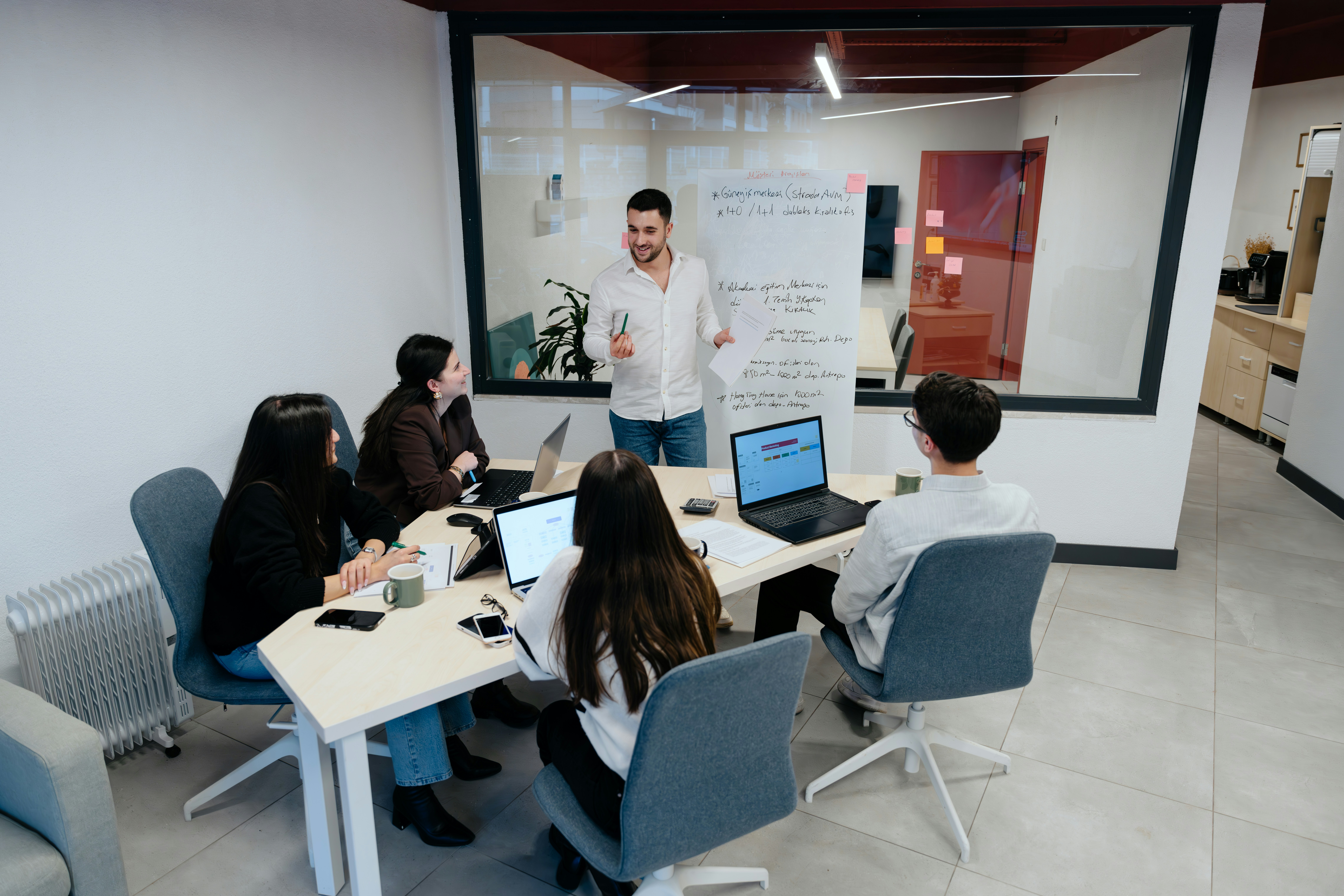 A senior leadership team reviewing employee insight data in a modern workspace, but captured naturally, not staged.